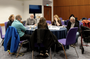 A group of attendees sitting at a round table at the Disability-inclusive climate emergency planning conference
