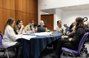 A group of attendees sitting at a round table at the Disability-inclusive climate emergency planning conference